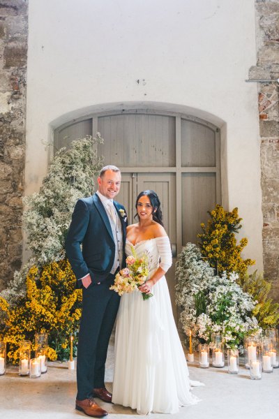 entrance door flowers surrounding and candles and bride and groom in shot