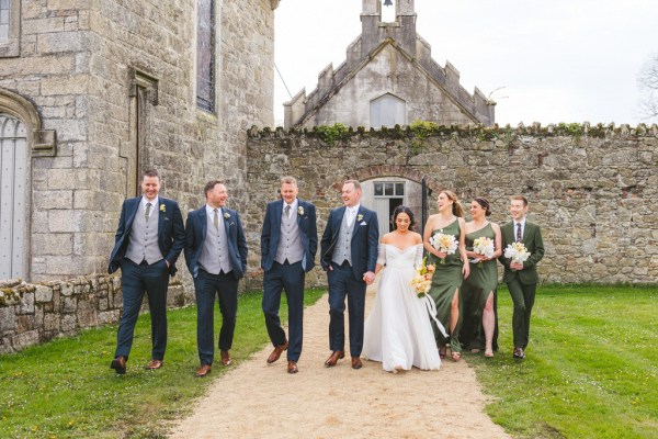 bride groom bridesmaids and groomsmen walk the pathway to wedding venue