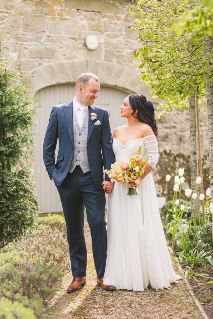 bride and groom in garden they look at each other