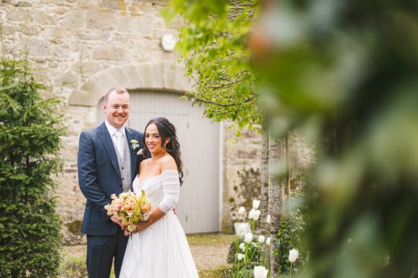 bride and groom in garden they are standing together holding each other