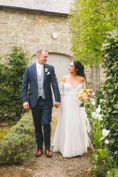 bride and groom in garden they begin to walk looking at each other