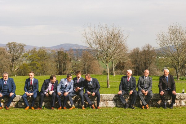 guests seated outside on bricked wall on grass