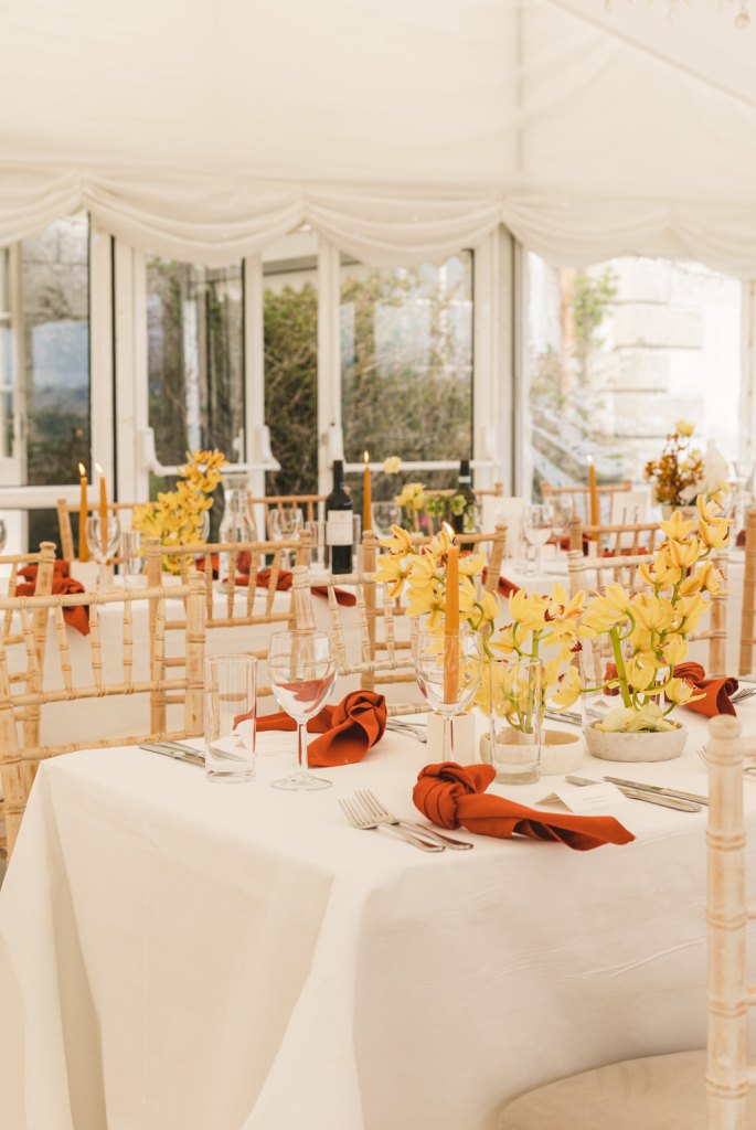 wide shot of interior dining room ballroom table setting windows and red serviettes wine bottles