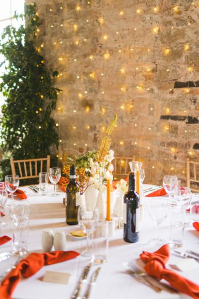 top table for bride and groom interior setting candles lit fairy lights in background