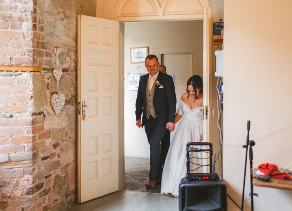 bride and groom entering ballroom