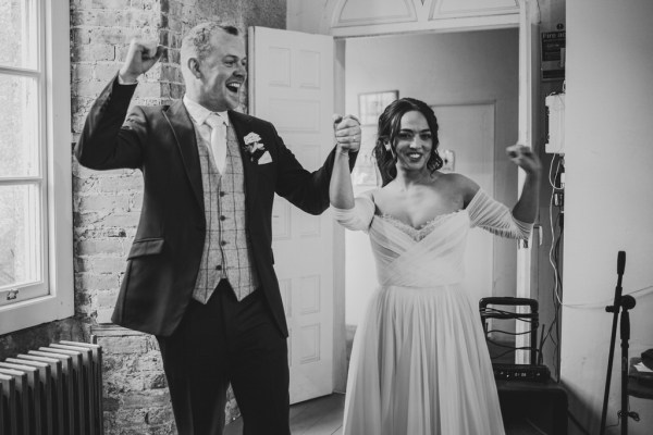 black and white shot of bride and groom entering ballroom