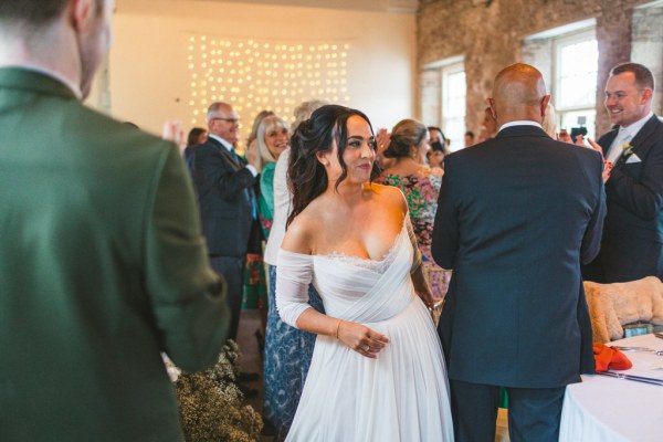 bride stands chatting to guests