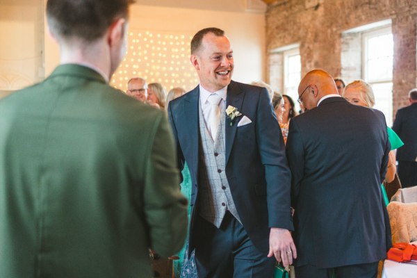 groom laughing with guests