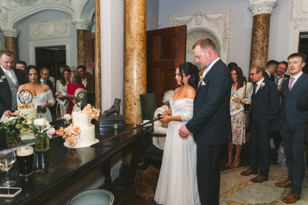 bride and groom cutting the white wedding cake