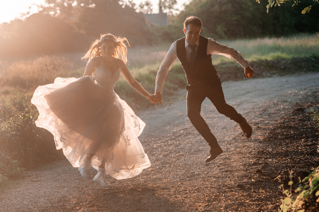 bride and groom dancing outside jump in the air