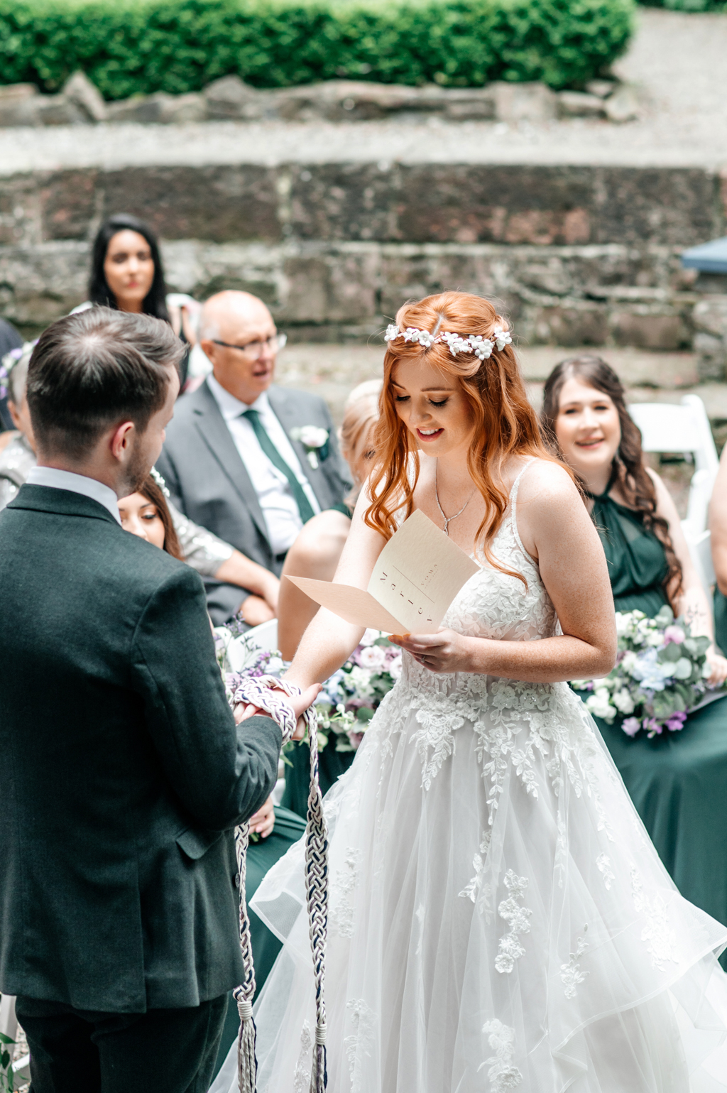 bride reads her vows out to groom