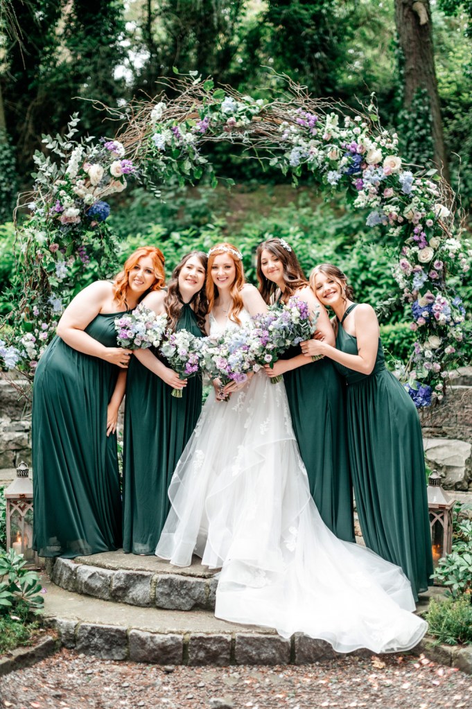 happy bridesmaids pose with the bride in center