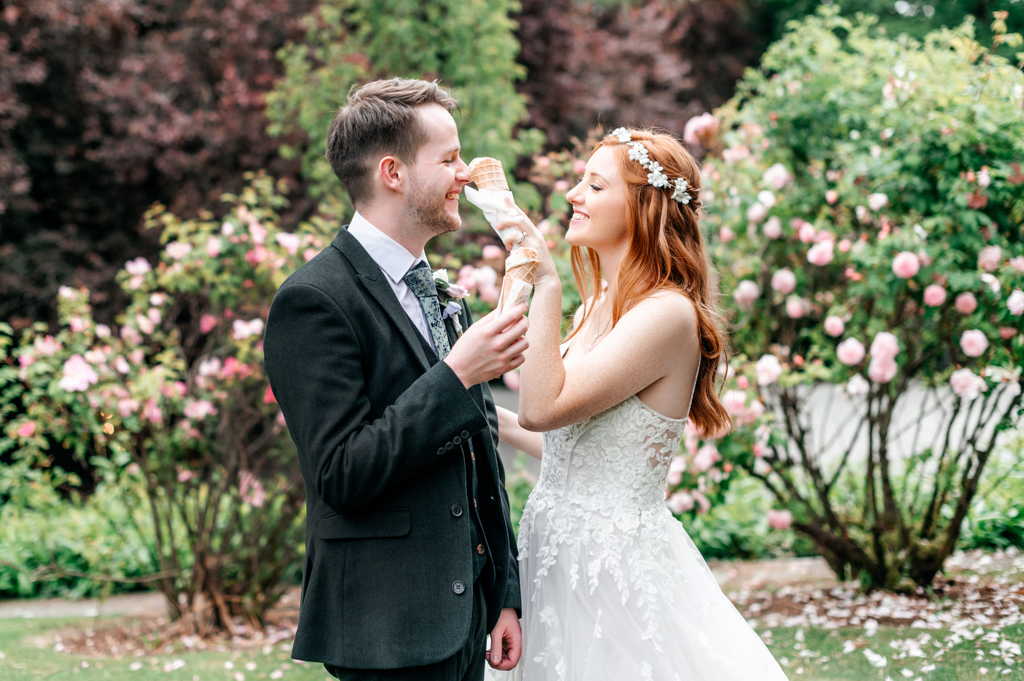 bride and groom share glass of champagne in garden setting