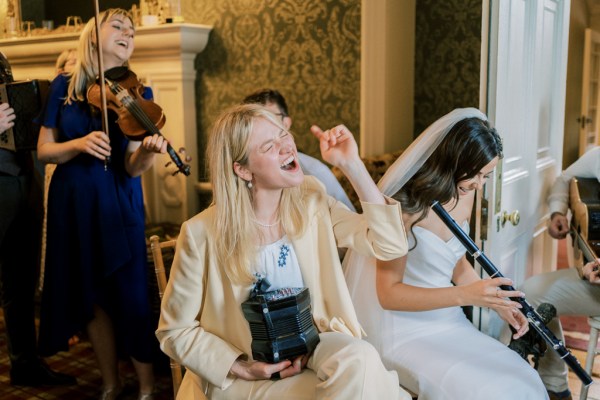 Musician sings while playing the accordion beside a bride