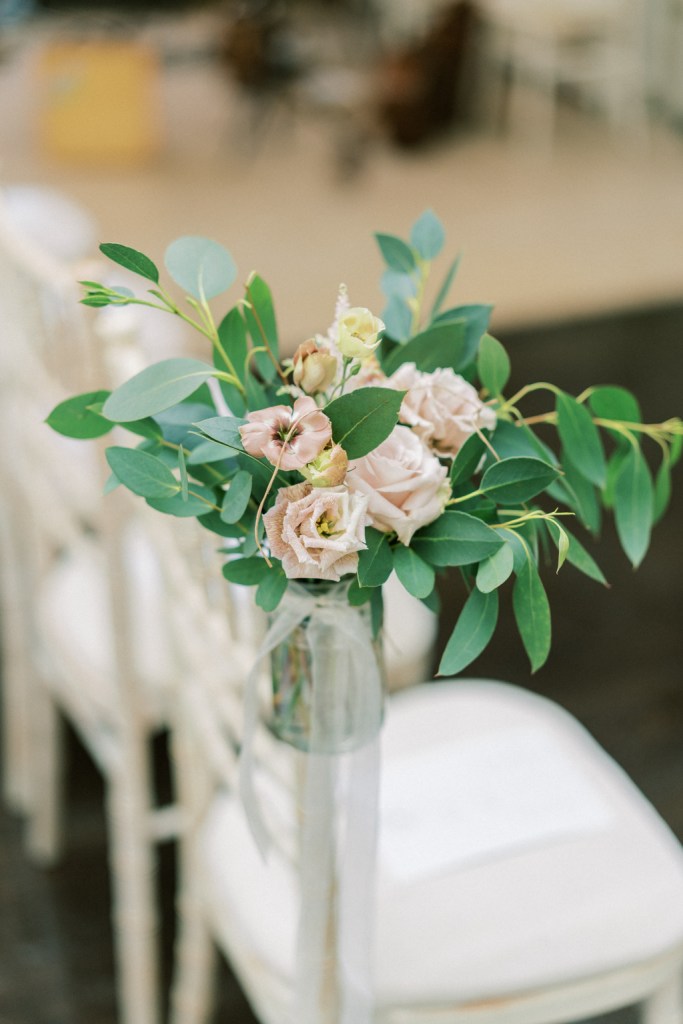 Pink flower display on chairs at wedding