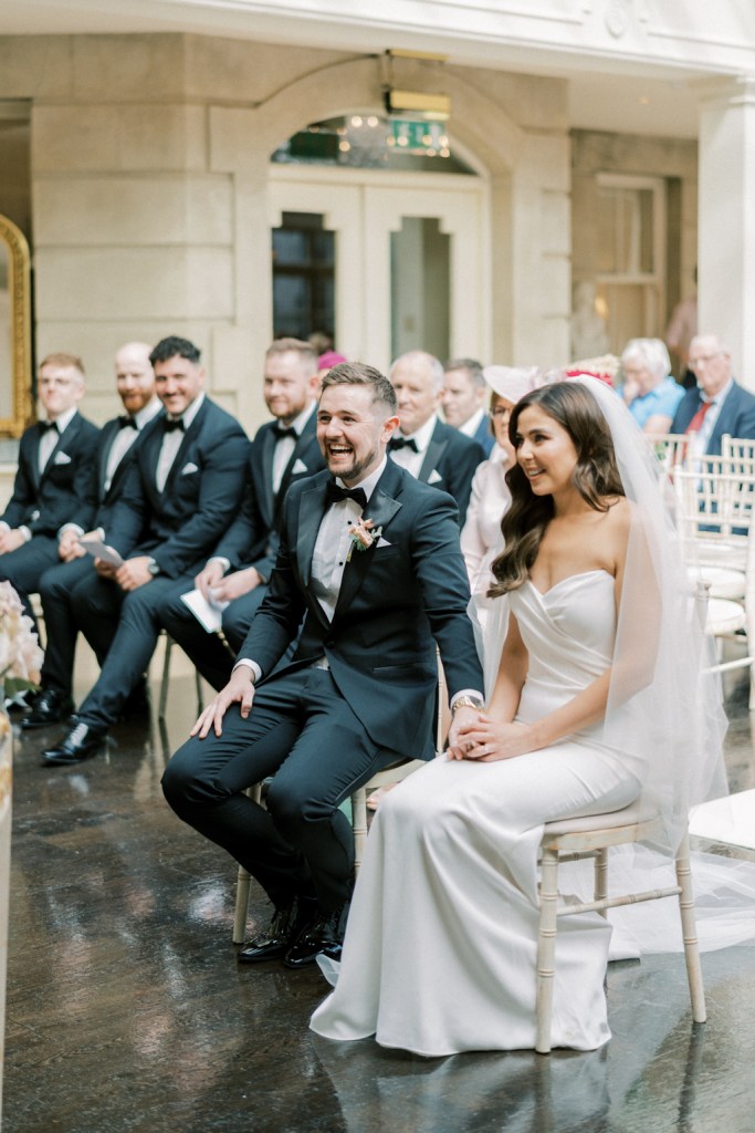 Bride and groom sit at the top of an aisle