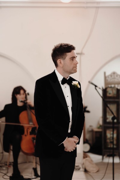 groom stands at alter waiting for bride