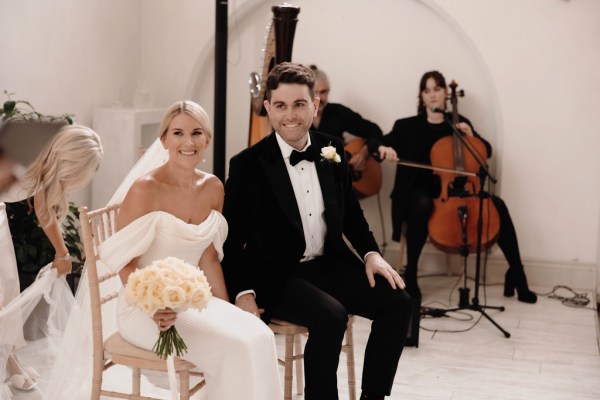 bride and groom are seated at alter to ceremony