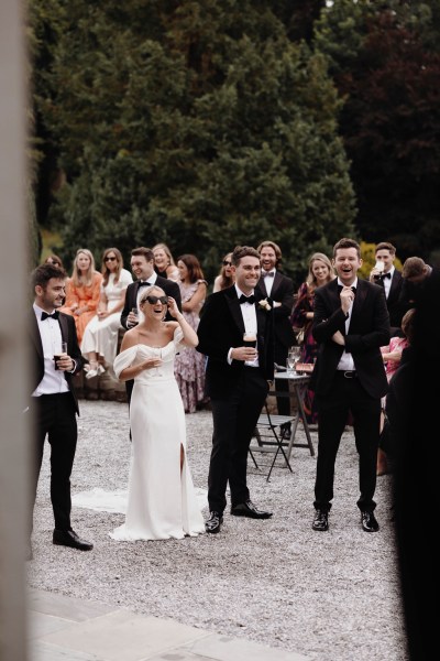 bride and groom cheers guests celebrating