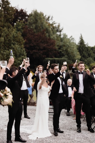 bride and groom cheers guests celebrating