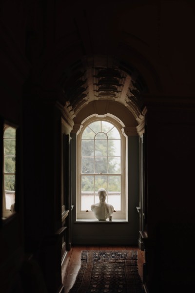 bride stands at large window