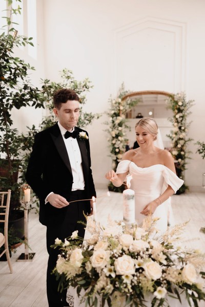 bride and groom sign marriage certificate table covered in white roses