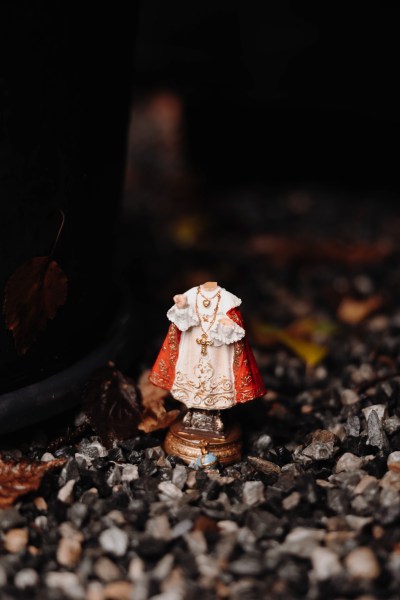 little holy priest statue on rocks