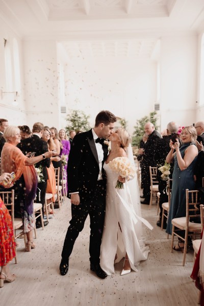 bride and groom kiss at the alter after ceremony ends