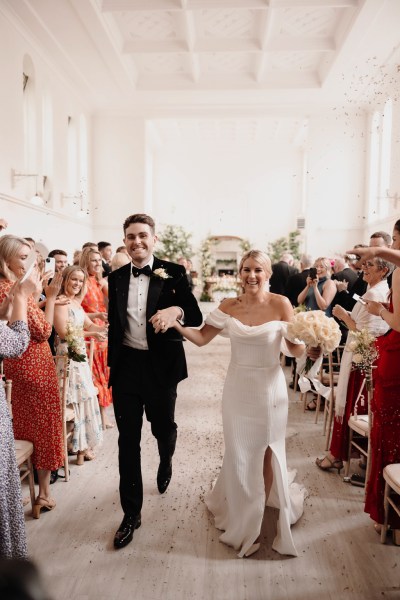 bride and groom exits ceremony holding hands