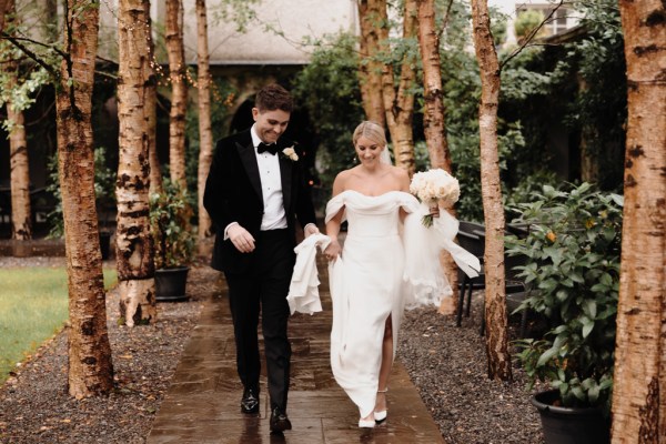 bride and groom kiss surrounded by trees in garden