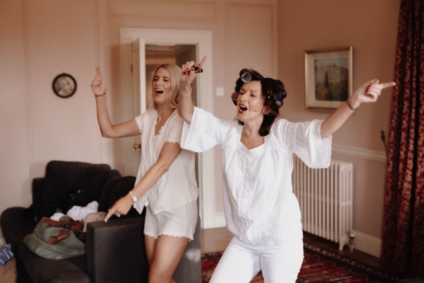 singing bride and bridesmaid they dance in room