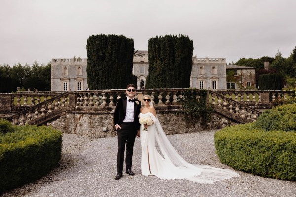 bride and groom standing in courtyard to wedding venue