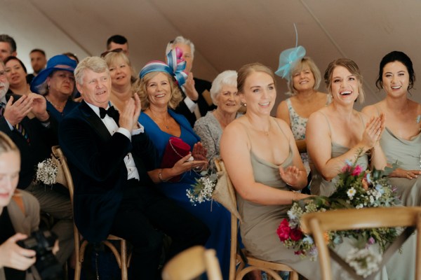 audience members seated during ceremony man claps