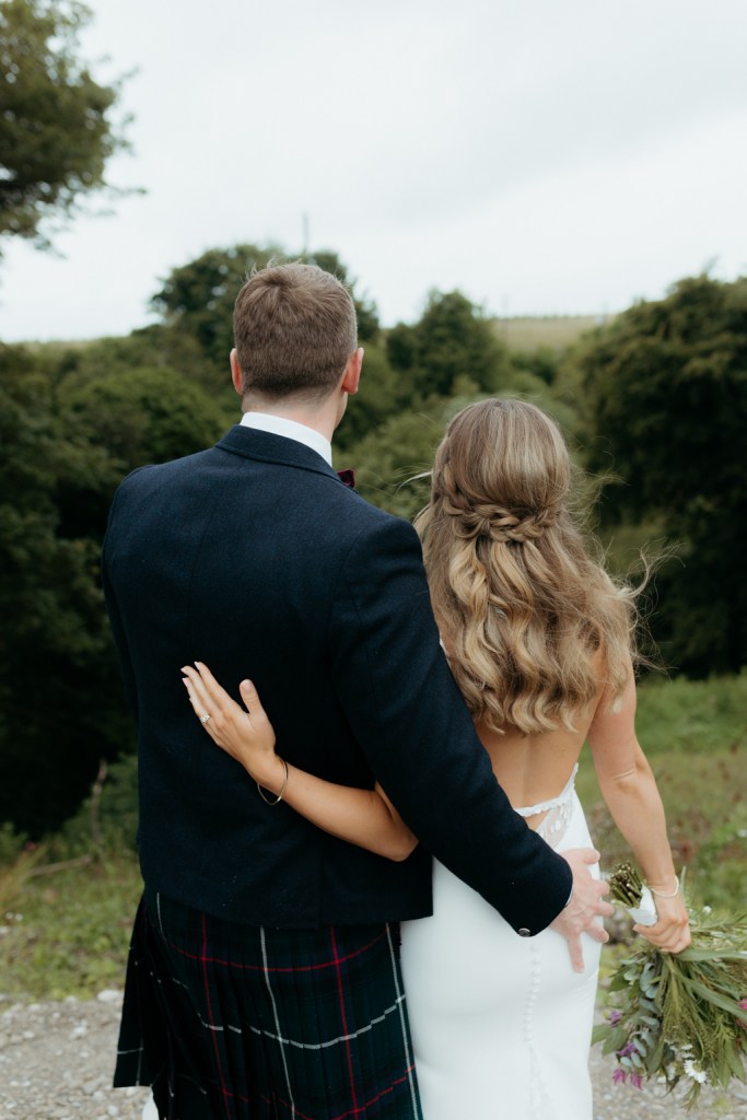 bride and groom in the garden together facing away from camera