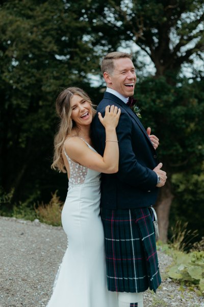 bride and groom laughing she is behind him