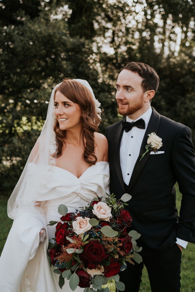 bride and groom look away from camera smiling