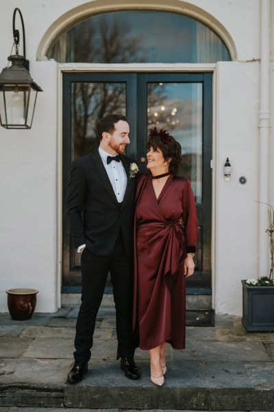 mother and son all smiles pose outside of house