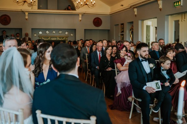 bride and groom seated from behind audience guest members sitting