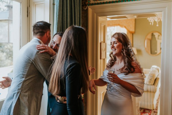 bride chats to friend groom hugs man