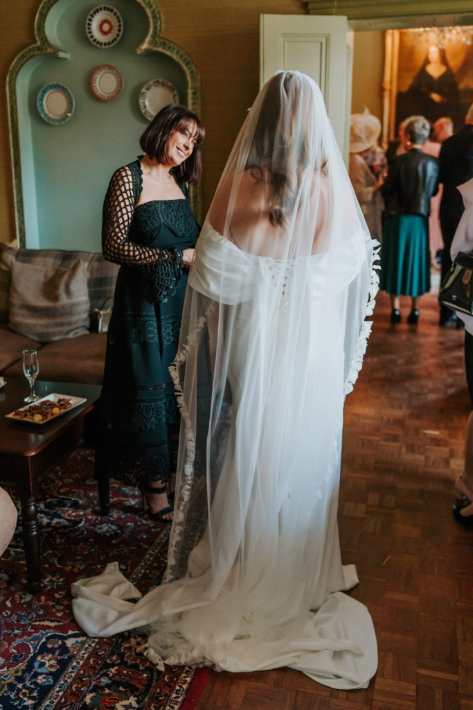 bride from behind veil detail chatting to friend