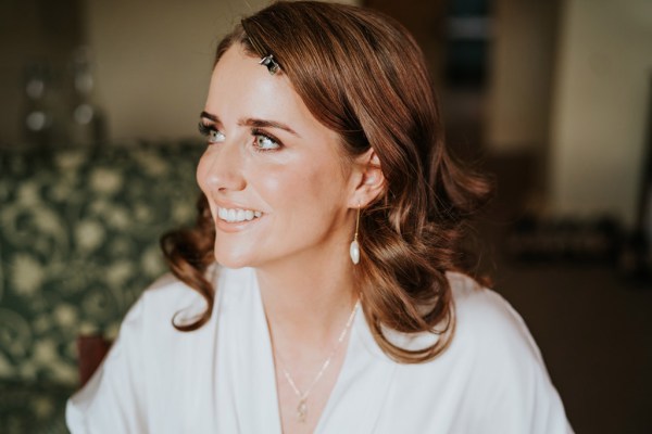 close up of brides necklace and earrings as she gets ready all smiles