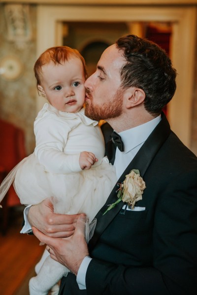 father kisses little baby girl on the cheek