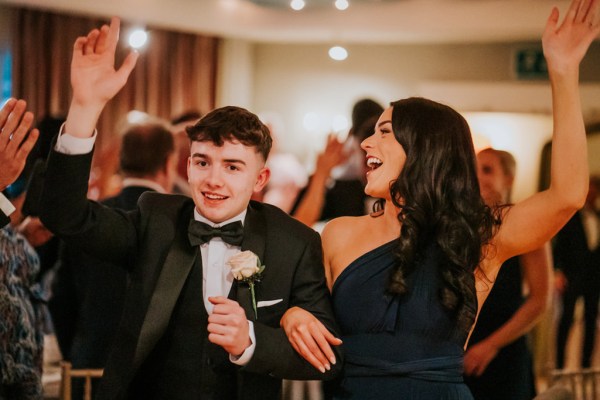 bridesmaid and man in suit smiling in ballroom