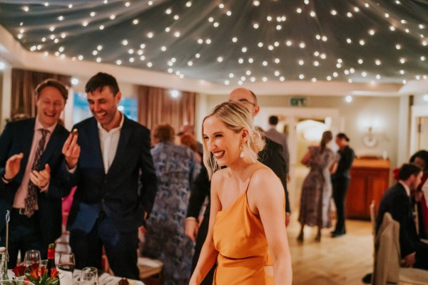 woman in orange dress is all smiles