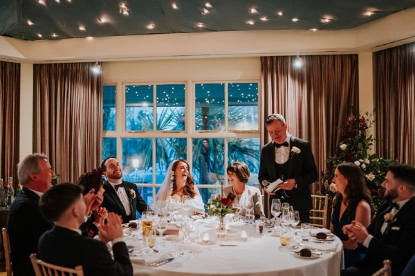 laughing bride groom and guests at table