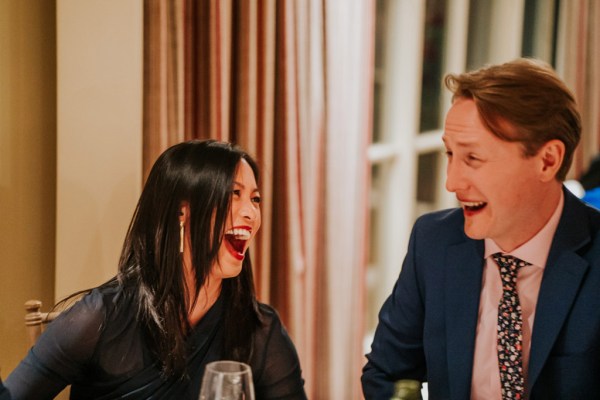 woman laughing with man in suit at table