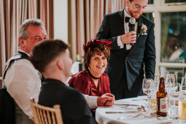 woman in red and groomsman giving speech