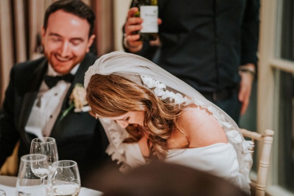 bride chuckles laughs her veil is in view groom laughing