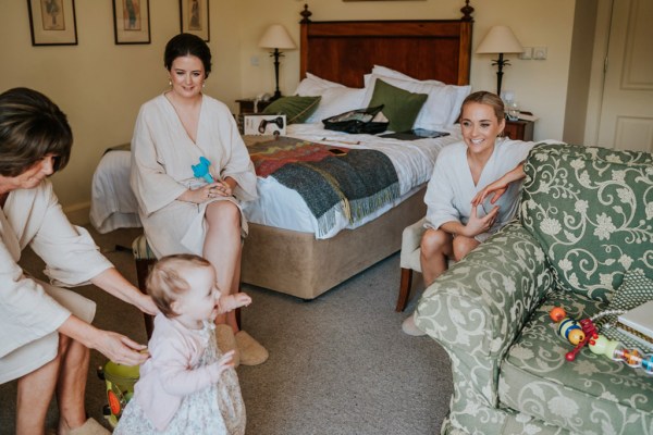 little girl playing with bride mother and bridesmaids