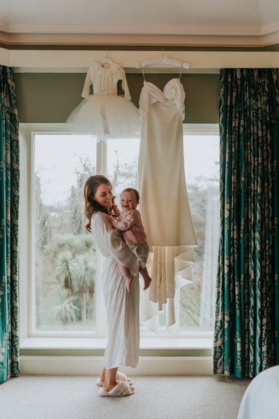 mother bride holding daughter up looking out window